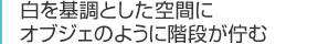 白を基調とした空間にオブジェのように階段が佇む